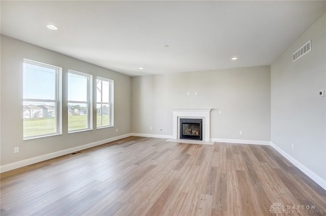 unfurnished living room featuring a fireplace and light hardwood / wood-style flooring