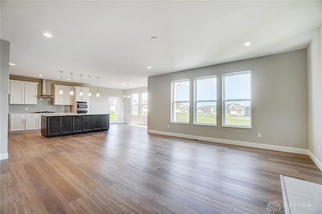 unfurnished living room with sink and light hardwood / wood-style flooring