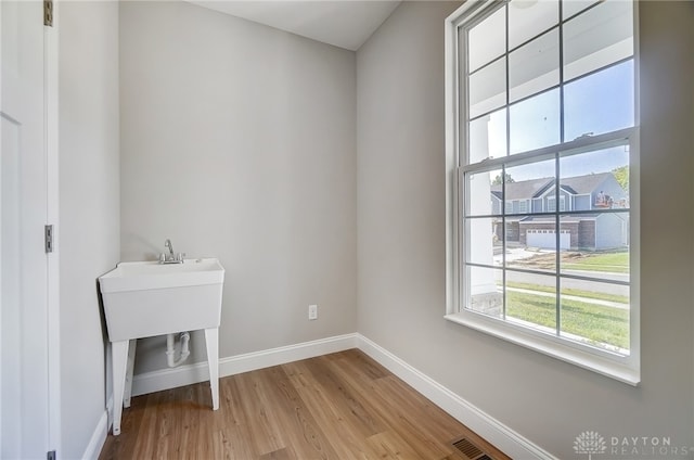 clothes washing area featuring light hardwood / wood-style flooring