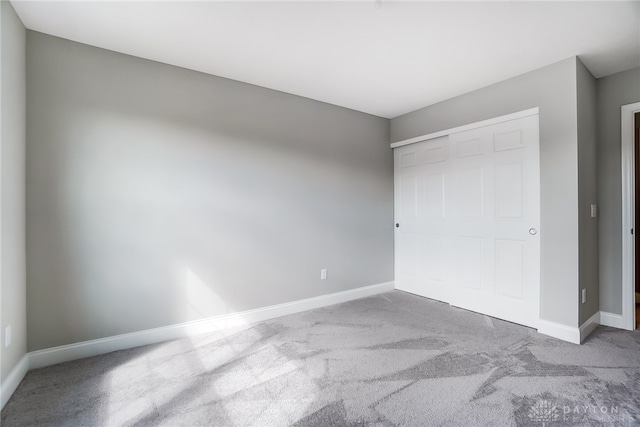 unfurnished bedroom featuring carpet and a closet