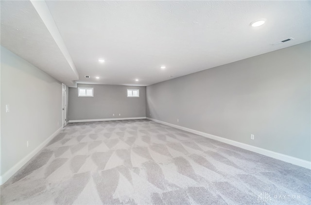 basement featuring light carpet