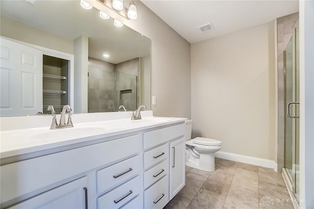 bathroom with tile patterned floors, toilet, vanity, and a shower with shower door