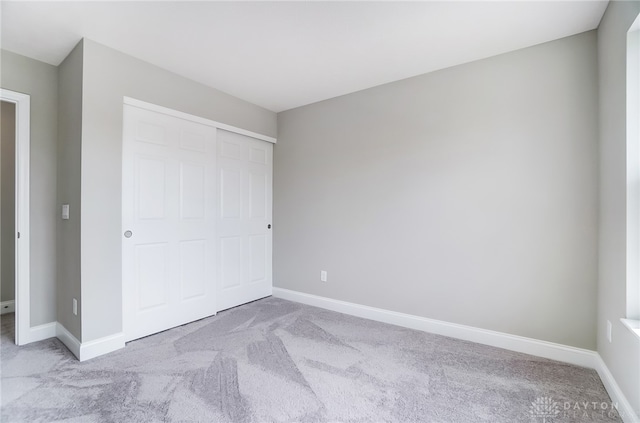 unfurnished bedroom with carpet floors and a closet