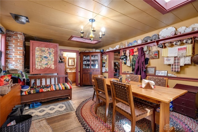 dining space featuring an inviting chandelier, wood-type flooring, and wooden ceiling