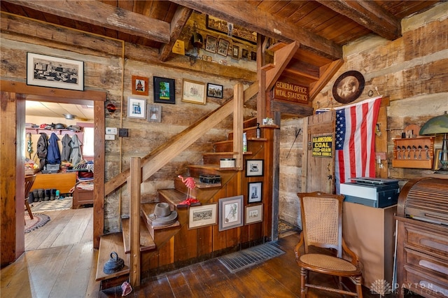 stairs with wood ceiling, wooden walls, wood-type flooring, and beam ceiling