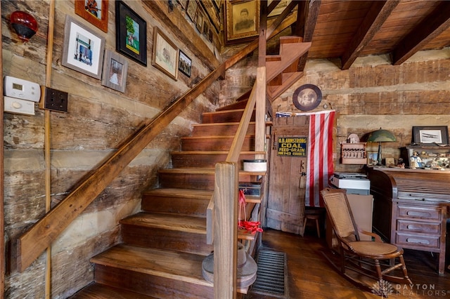 stairway with beam ceiling, hardwood / wood-style flooring, and wooden ceiling