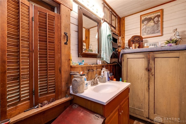 bathroom with vanity and wooden walls