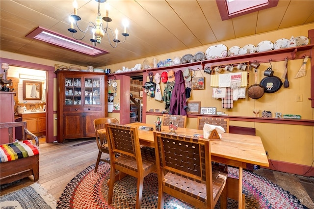 dining space featuring wooden ceiling, light hardwood / wood-style flooring, and a notable chandelier