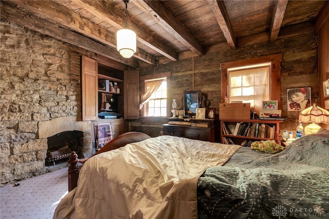 bedroom with wooden ceiling, beam ceiling, and a fireplace