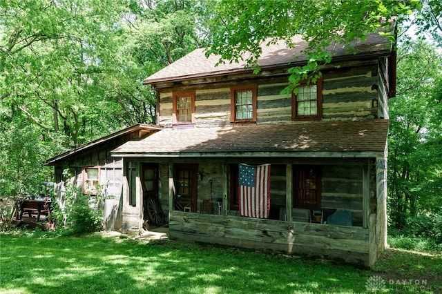 rear view of house featuring a yard