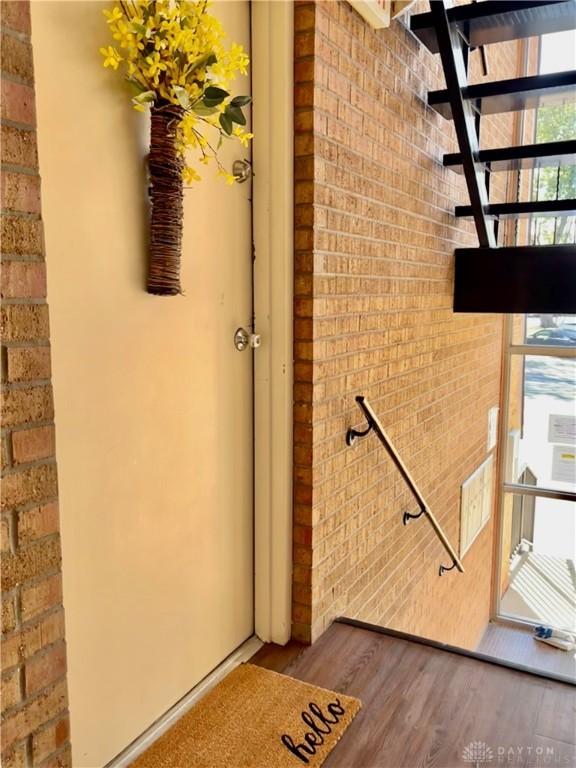 interior space featuring brick wall and hardwood / wood-style floors