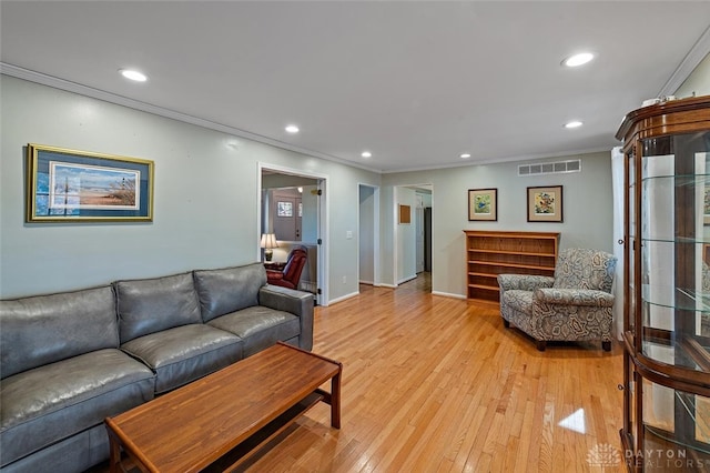 living room with light hardwood / wood-style flooring and ornamental molding