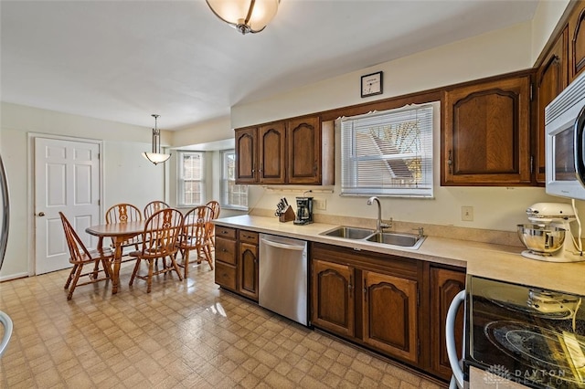 kitchen featuring stainless steel appliances, decorative light fixtures, sink, and plenty of natural light