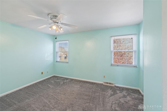 carpeted empty room featuring a wealth of natural light and ceiling fan