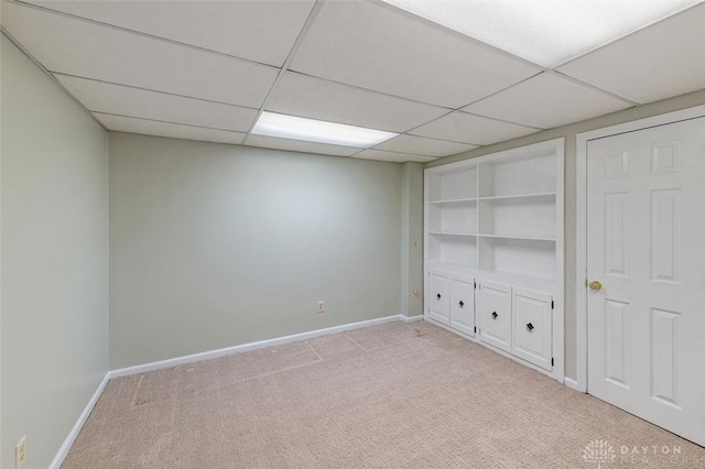 interior space featuring light carpet and a paneled ceiling