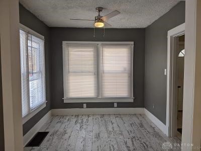 unfurnished dining area with ceiling fan, a textured ceiling, and light wood-type flooring