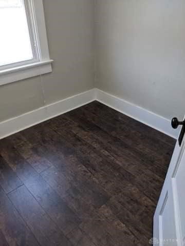 unfurnished room featuring dark wood-type flooring