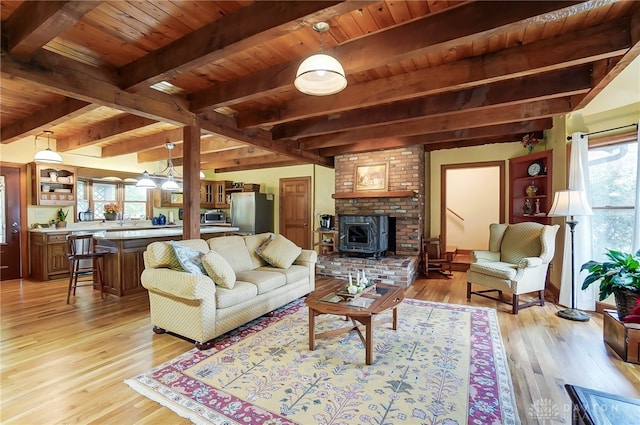 living room featuring beamed ceiling, light hardwood / wood-style flooring, and wooden ceiling