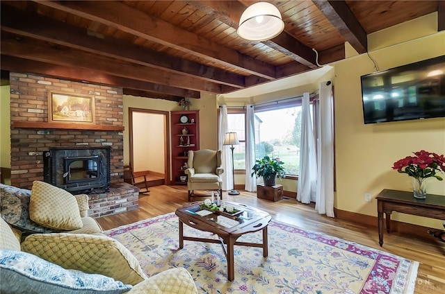 living room featuring light hardwood / wood-style floors, wood ceiling, beam ceiling, and a wood stove