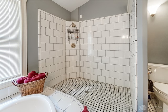 bathroom with toilet, tile patterned floors, and tiled shower