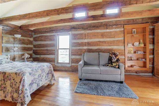 bedroom featuring vaulted ceiling with beams and wood-type flooring