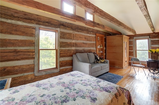 bedroom with vaulted ceiling with beams and light wood-type flooring