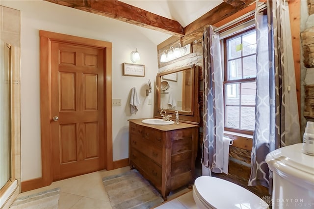 bathroom featuring lofted ceiling, a shower, toilet, vanity, and tile patterned floors