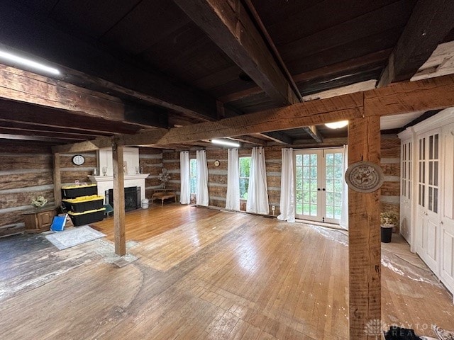 interior space with french doors, wooden walls, and wood-type flooring