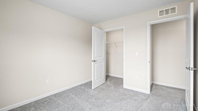 unfurnished bedroom featuring a closet and light colored carpet