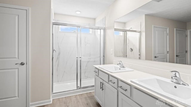 bathroom featuring vanity, a shower with shower door, and hardwood / wood-style flooring