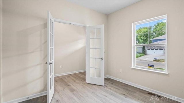 unfurnished bedroom with light hardwood / wood-style floors and french doors