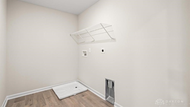 clothes washing area featuring electric dryer hookup, hookup for a washing machine, and hardwood / wood-style floors