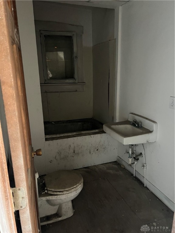 bathroom featuring sink, a bathtub, and toilet