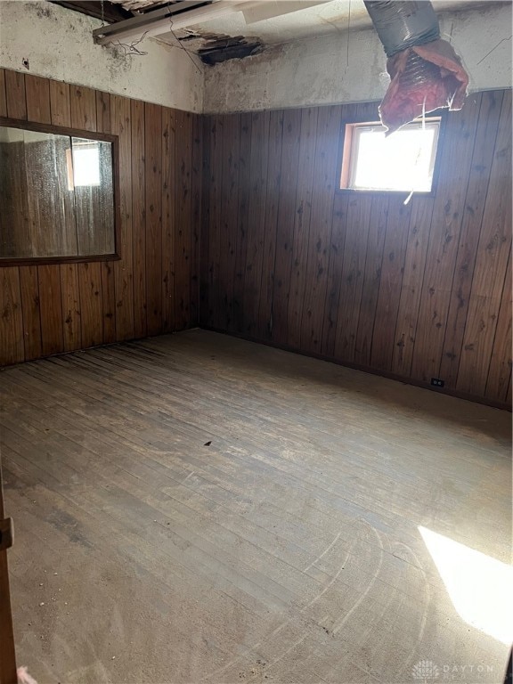 basement with wooden walls and wood-type flooring