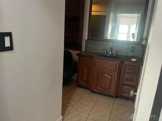 interior space featuring backsplash, sink, and tile patterned floors