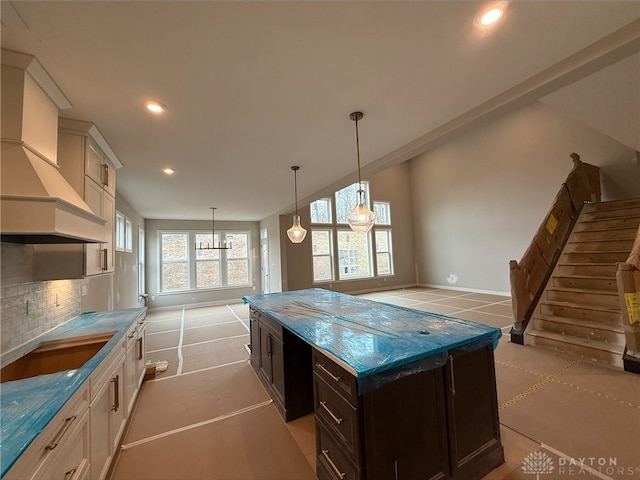 kitchen with premium range hood, recessed lighting, cooktop, dark brown cabinets, and backsplash