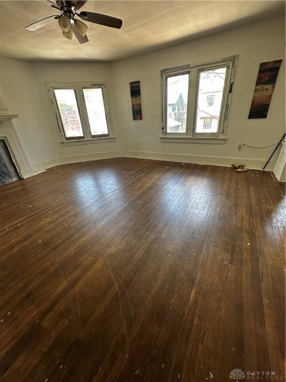 unfurnished living room featuring dark hardwood / wood-style floors, a healthy amount of sunlight, and ceiling fan