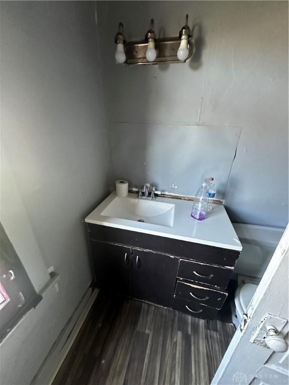 bathroom featuring vanity, wood-type flooring, and toilet