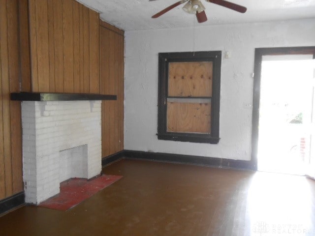 unfurnished living room with dark wood-type flooring and ceiling fan