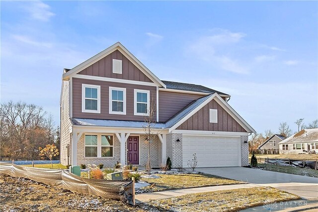 view of front of property featuring board and batten siding, concrete driveway, brick siding, and a garage