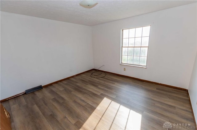 spare room with hardwood / wood-style floors and a textured ceiling