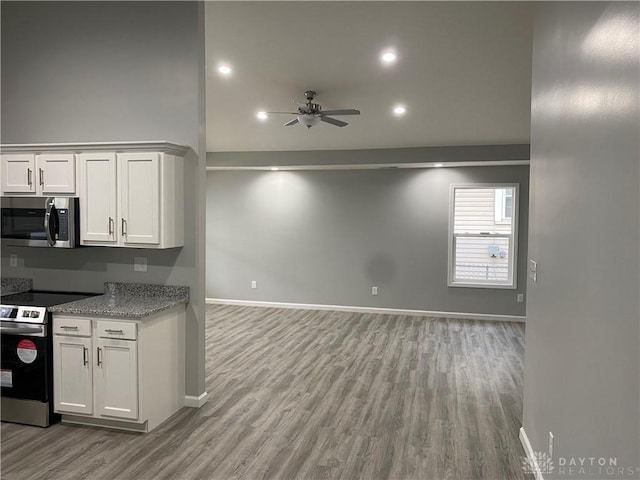 kitchen with light hardwood / wood-style flooring, white cabinets, and stainless steel appliances