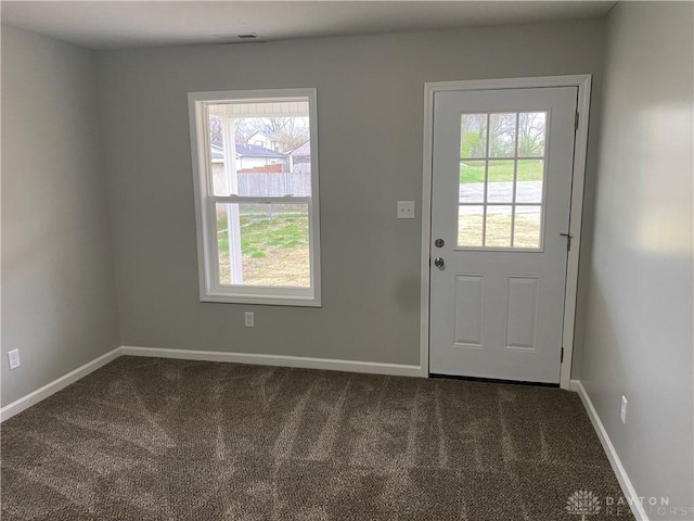 doorway to outside featuring dark carpet