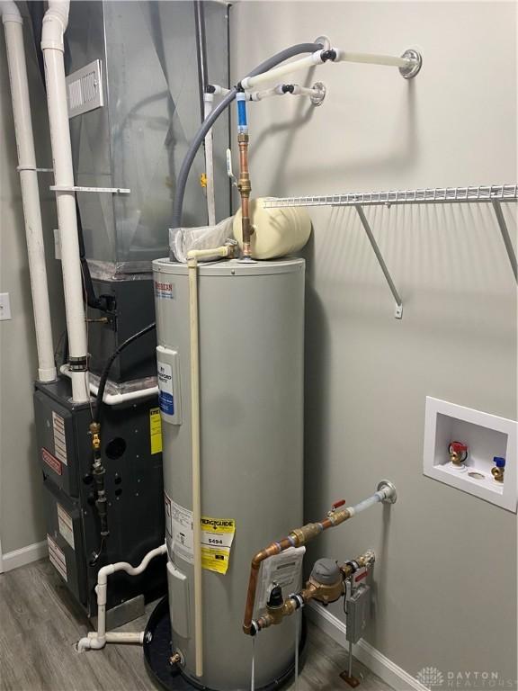 utility room with electric water heater and heating unit