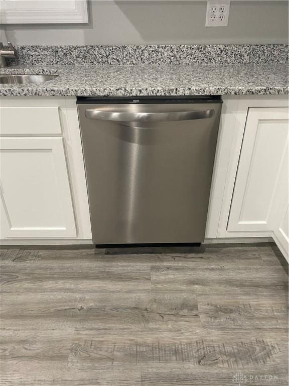 room details featuring dishwasher, white cabinetry, light stone countertops, and sink