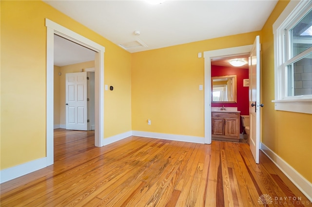 unfurnished room featuring sink and light hardwood / wood-style floors