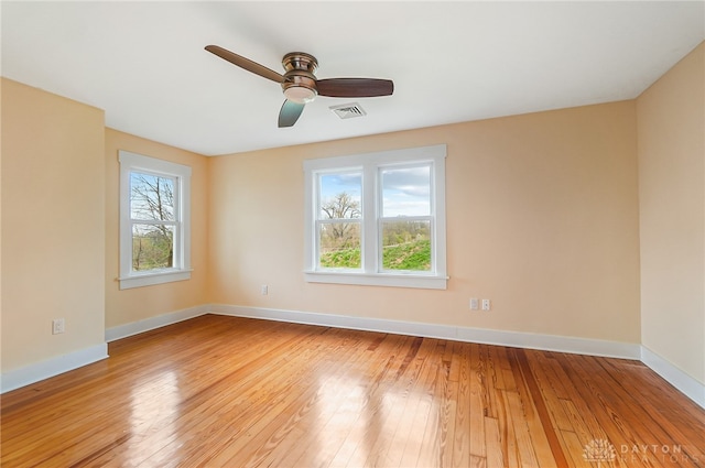 spare room with a healthy amount of sunlight, wood-type flooring, and ceiling fan