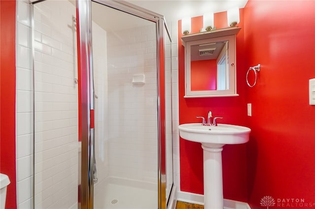 bathroom with a shower with shower door and toilet