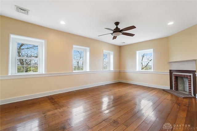 unfurnished living room featuring a fireplace, hardwood / wood-style flooring, and ceiling fan