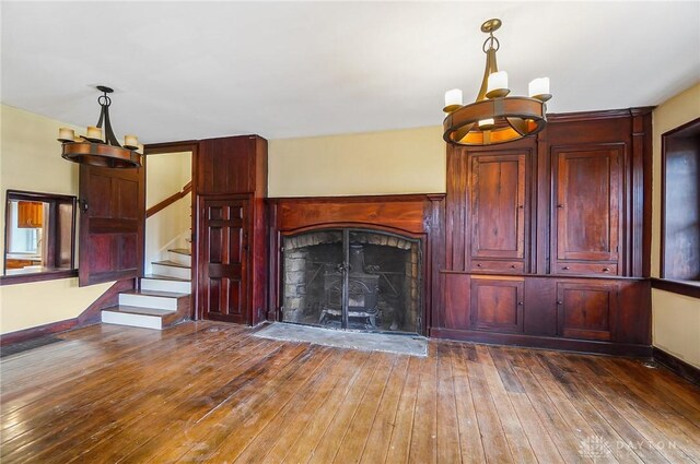 unfurnished living room featuring hardwood / wood-style flooring and a notable chandelier